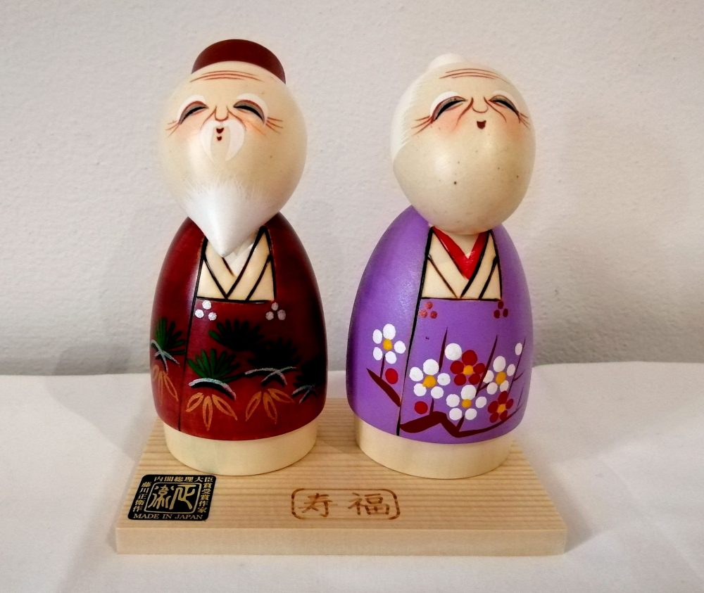 Kokeshi coppia di anziani bambola dipinta amano su legno.