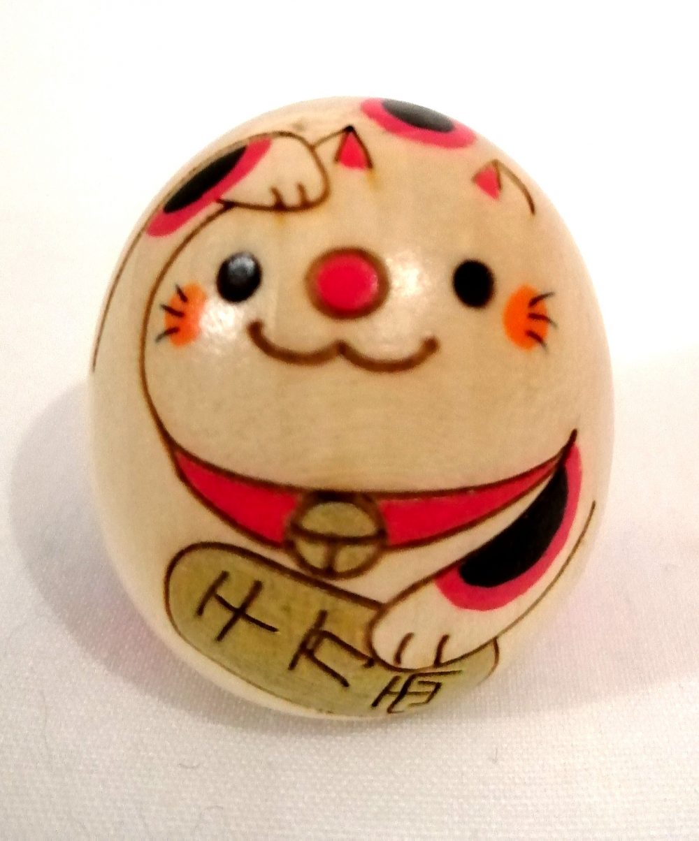 Kokeshi a forma di maneki neko, gatto porta fortuna.