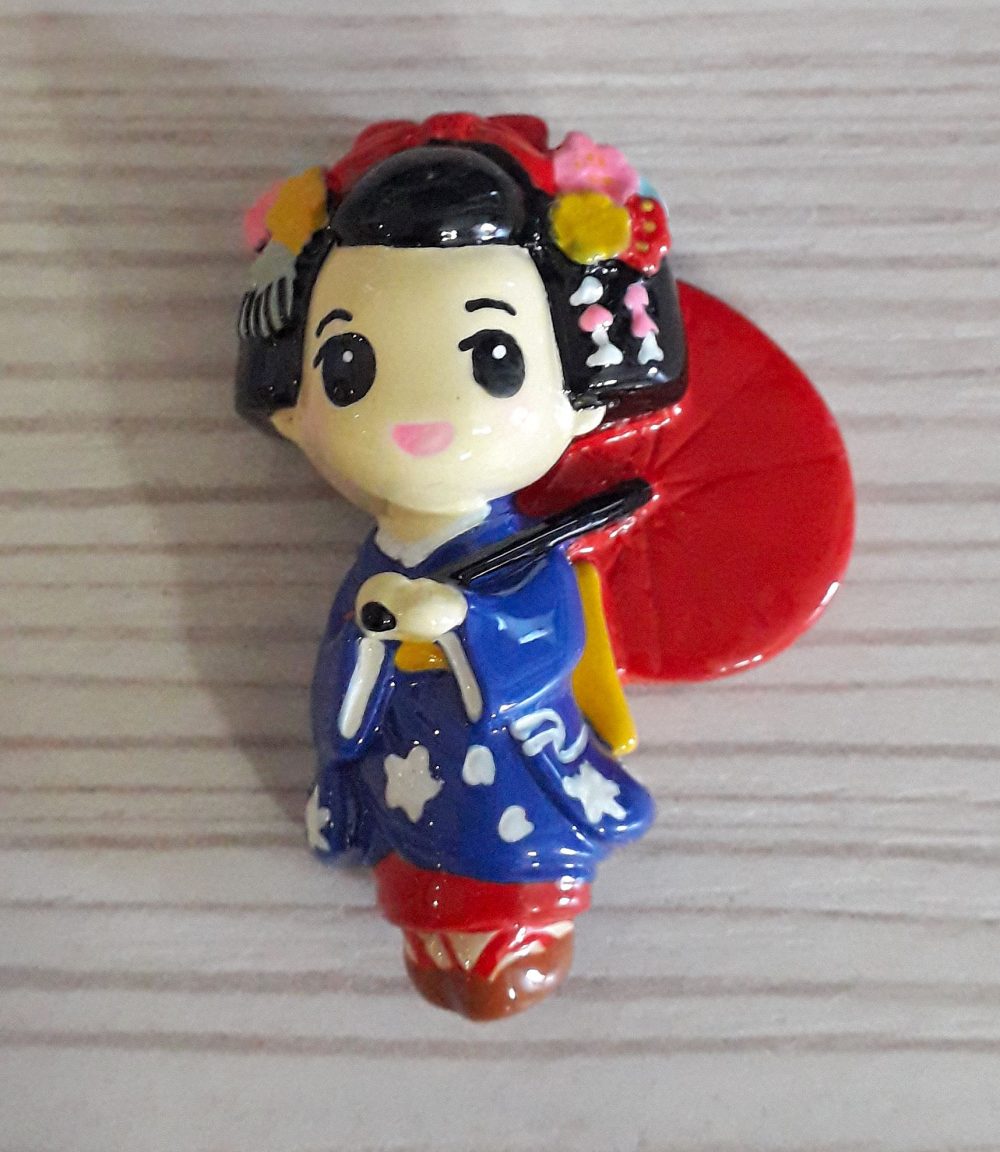 Calamita maiko blu con ombrellino rosso.