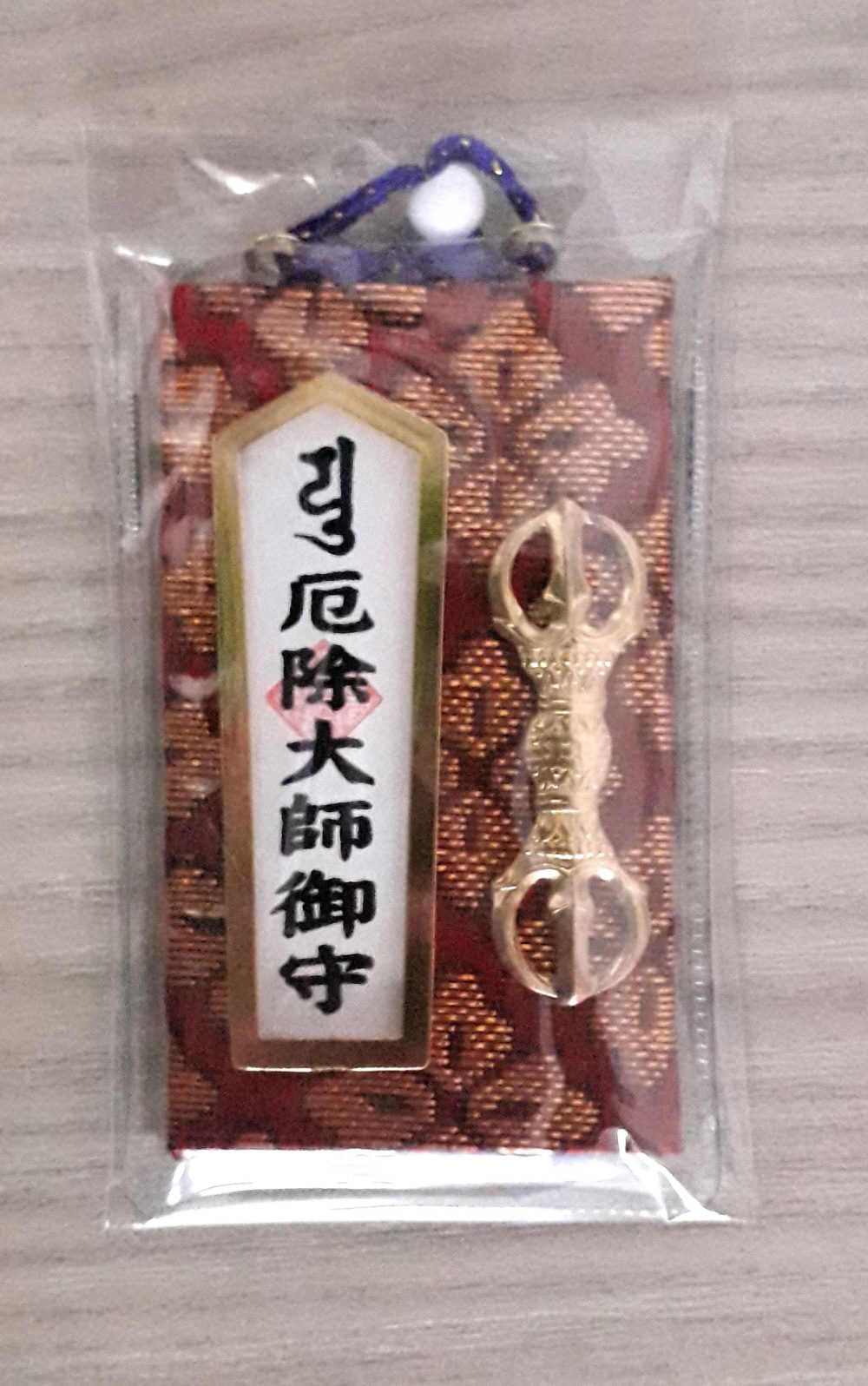 Omamori Daishi allOmamori di Daishi, Kobo Daishi, buddista giapponese, entrato a far parte dell'ordine con il nome religioso Kukai, il quale dopo un viaggio in Cina, tornò nella sua madre patria e fondò il tempio Kongobu-ji, sul monte Koya, e divenne uno dei maggiori del Giappone.