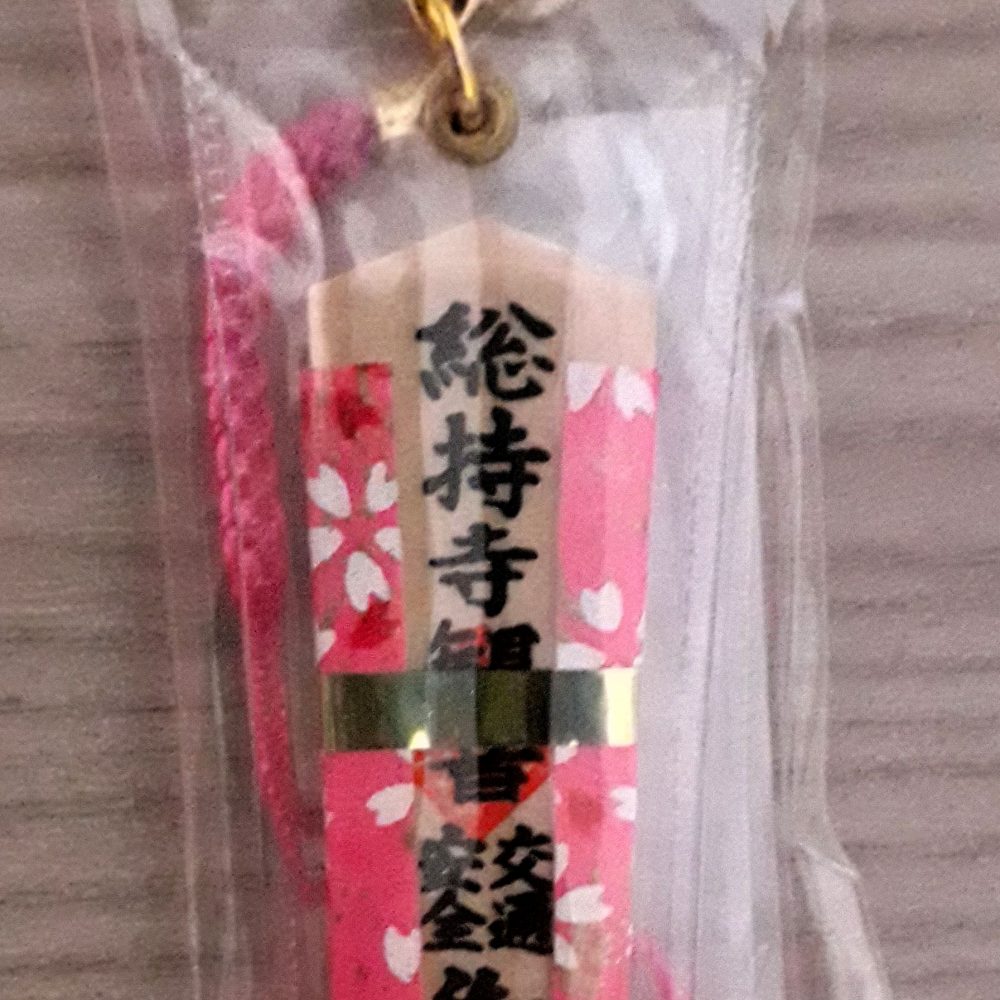 Omamori a ciondolo in legno, rivestito con stoffa di colore rosa, per la sicurezza stradale.