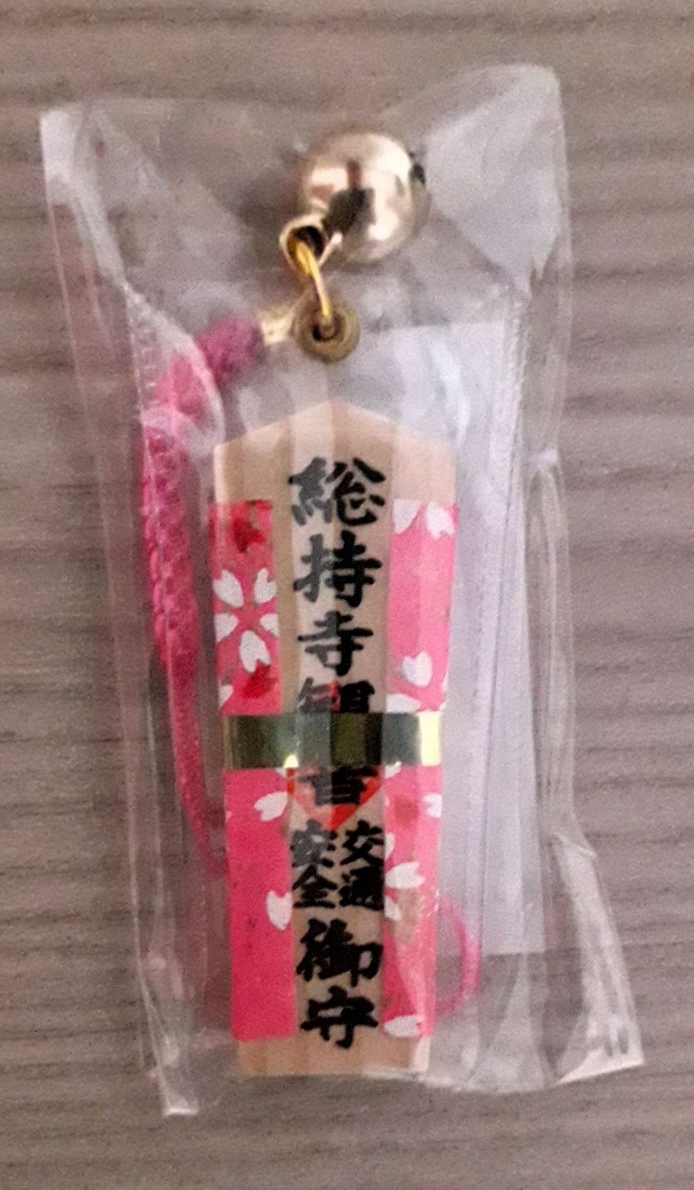 Omamori a ciondolo in legno, rivestito con stoffa di colore rosa, per la sicurezza stradale.