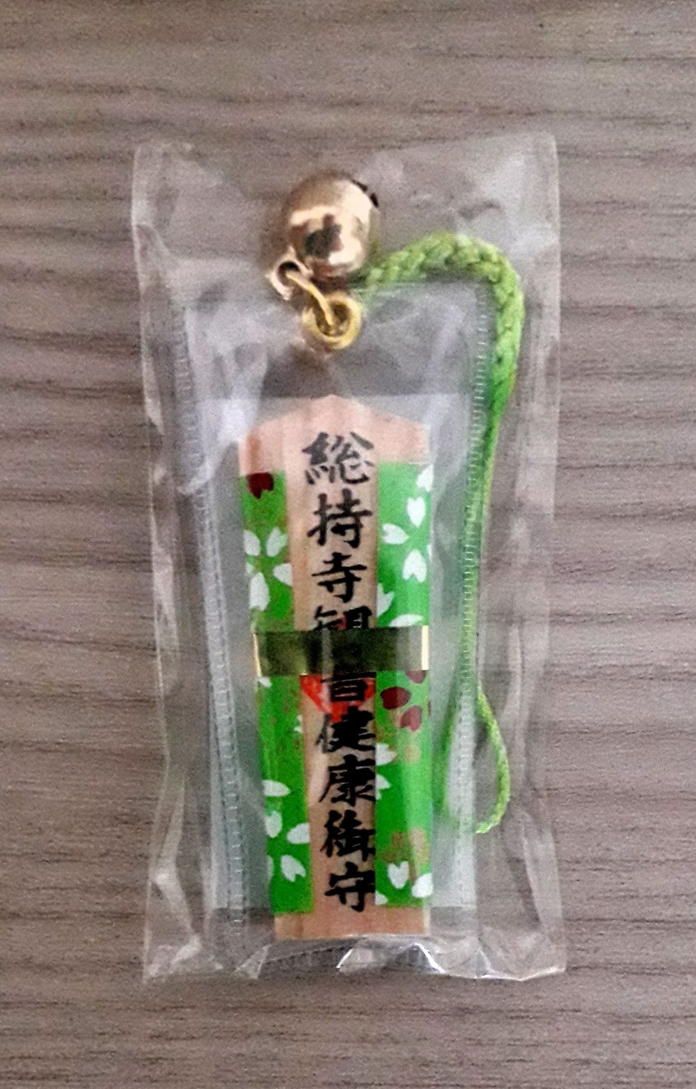 Omamori salute colore verde. Omamori a ciondolo in legno, rivestito con stoffa di colore verde, per augurare o augurarsi una buona salute.