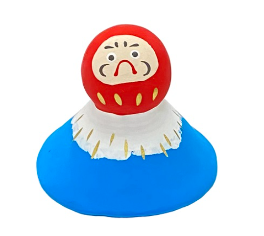 Una piccola rappresentazione del Fuji-ama, ovvero il monte Fuji, il più famoso del Giappone, con un daruma sulla cima. Carinissima statuina da posizionare dove più vi piace, due icone del Giappone da dover avere.