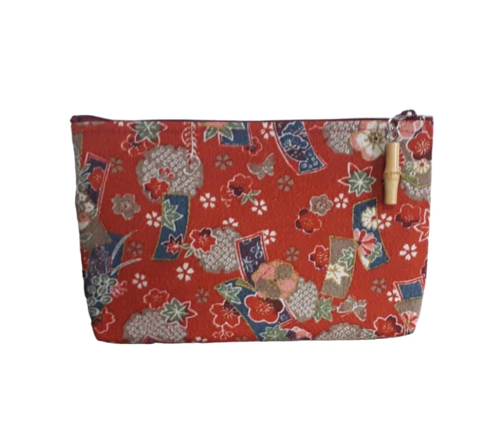 Pochette, o bustina porta tutto, in chirimene rayoin, stoffa giapponese con cui vengono fatti i kimono, o molto utilizzata per altri oggetti. Di dimensioni non troppo grandi in modo tale da poterla tenere con sé anche nella borsa o nello zaino, con fantasia floreale su colore rosso.