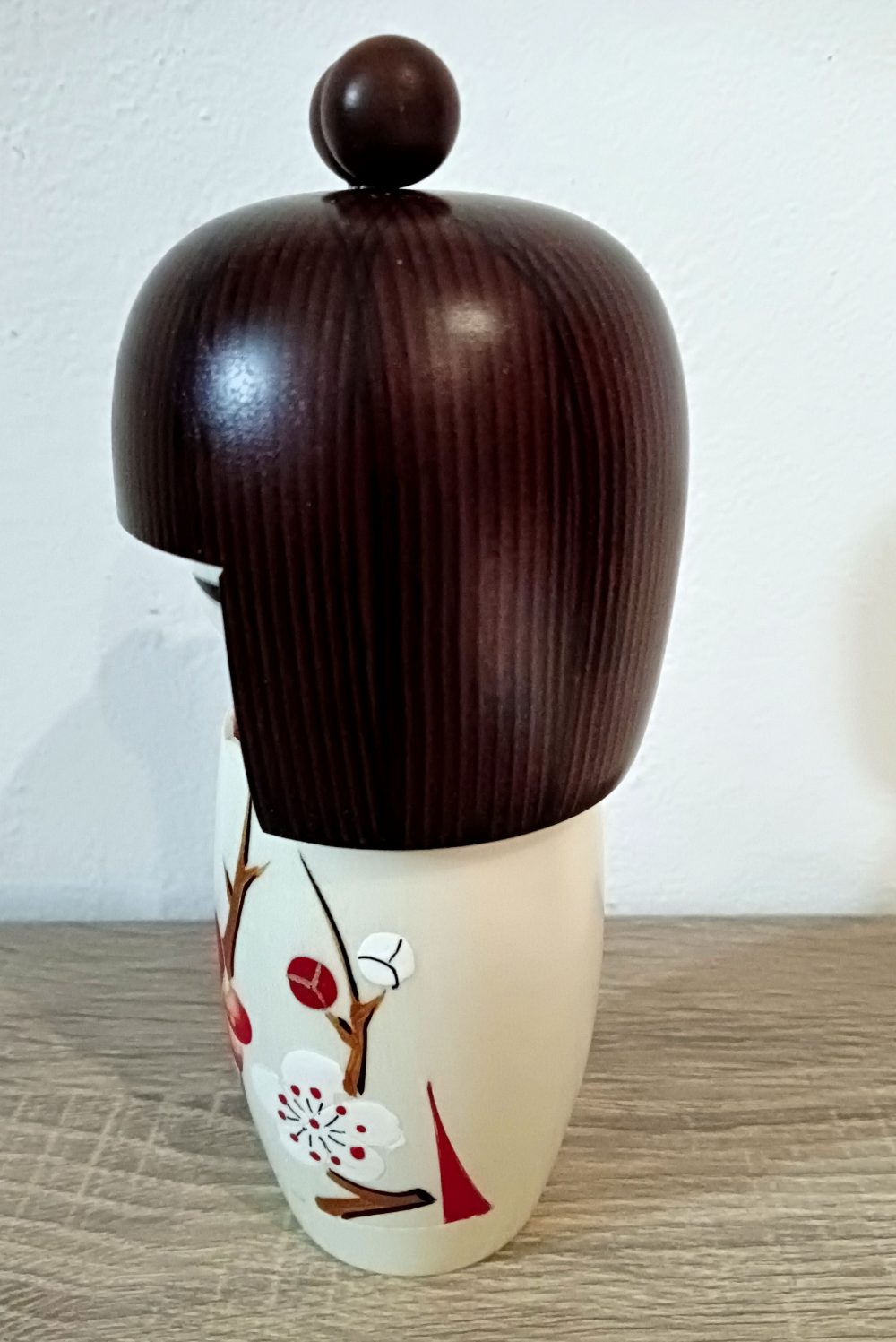 Questa è una Kokeshi Shingata, ovvero creativa, hanno il busto più corto di quelle tradizionali e più arrotondato, con colori e motivi più moderni. Hanno il busto più corto di quelle tradizionali e più arrotondato, con colori e motivi più moderni. Il nome originale di questa kokeshi è "Haru no yume", ovvero sogno di primavera. Sul kimono bellissimi fiori primaverili, capelli castani e codini. Molto bella dai colori tenui, ed un volto che trasmette serenità.