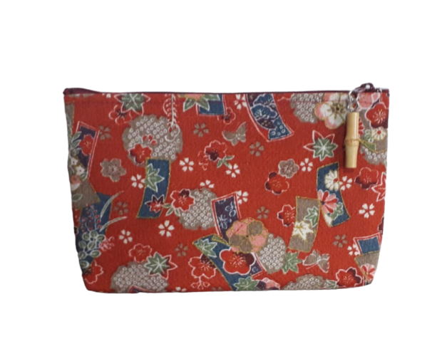 Pochette, o bustina porta tutto, in chirimene rayoin, stoffa giapponese con cui vengono fatti i kimono, o molto utilizzata per altri oggetti. Di dimensioni non troppo grandi in modo tale da poterla tenere con sé anche nella borsa o nello zaino, con fantasia floreale su colore rosso.